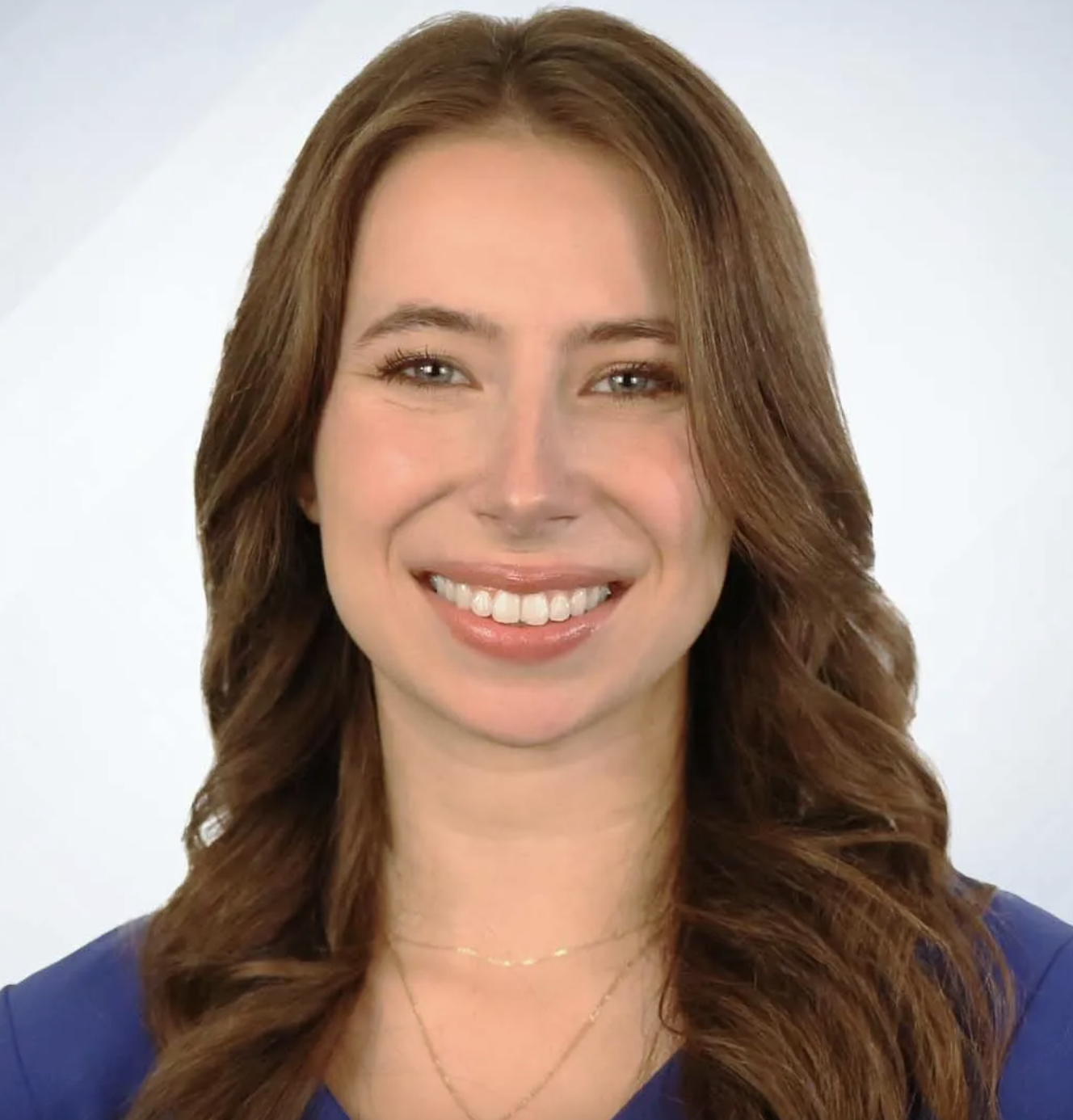 A headshot of Leah Crowley against a gray background.